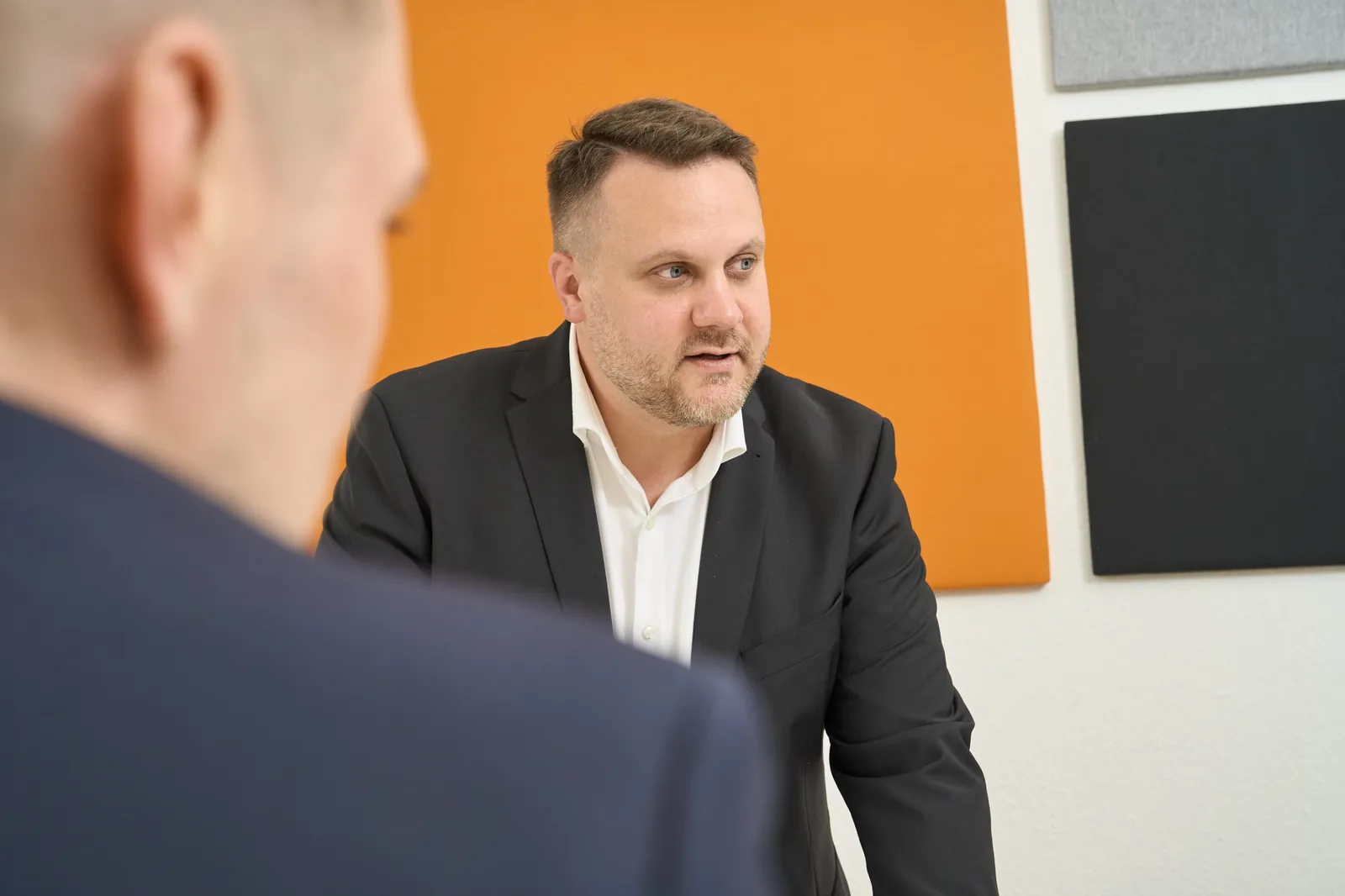 Foto Rechtsanwalt, Fachanwalt für gewerblichen Rechtsschutz, erläutert im Gespräch die Strategie für eine Schutzrechtsanmeldung